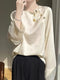 Beigefarbene Jacquard-Bluse mit Perlmuttknöpfen und Pailletten